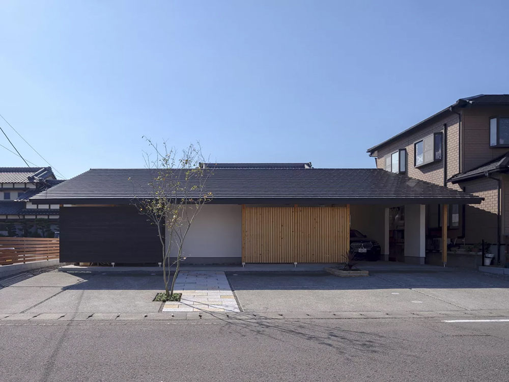 外観は軒が深く、重心を低く高さを抑えることで重厚感を持たせ、全天候型のインナーガレージを併設